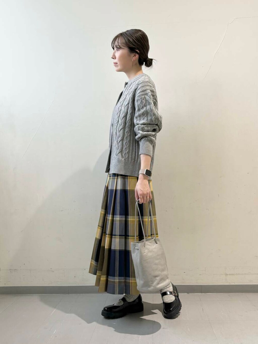 グレー系のカーディガン/ボレロ、グレー系のショルダーバッグ、ブルー系のスカートを着用したレディースの秋コーディネートの5枚目の写真