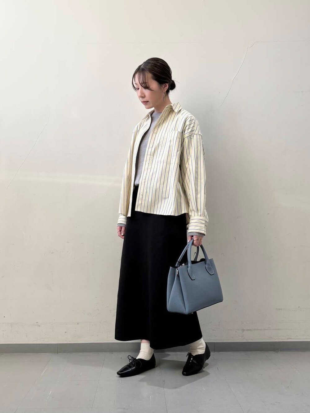 ブラック系のその他シューズ、ブルー系のショルダーバッグ、グレー系のニット/セーターを着用したレディースの冬コーディネートの2枚目の写真