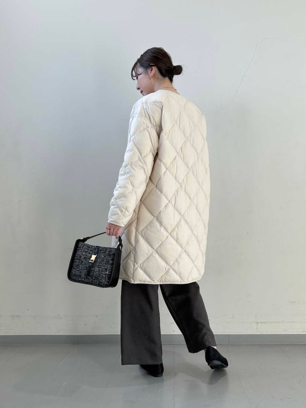 ホワイト系のダウンジャケット/コート、ブラック系のショルダーバッグ、ブラック系のローファーを着用したレディースの冬コーディネートの9枚目の写真