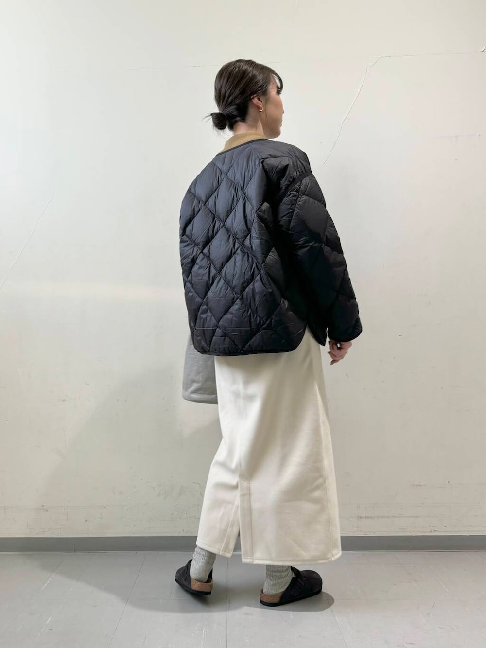 ブラック系のダウンジャケット/コート、グレー系のショルダーバッグ、グリーン系のニット/セーターを着用したレディースの秋コーディネートの5枚目の写真