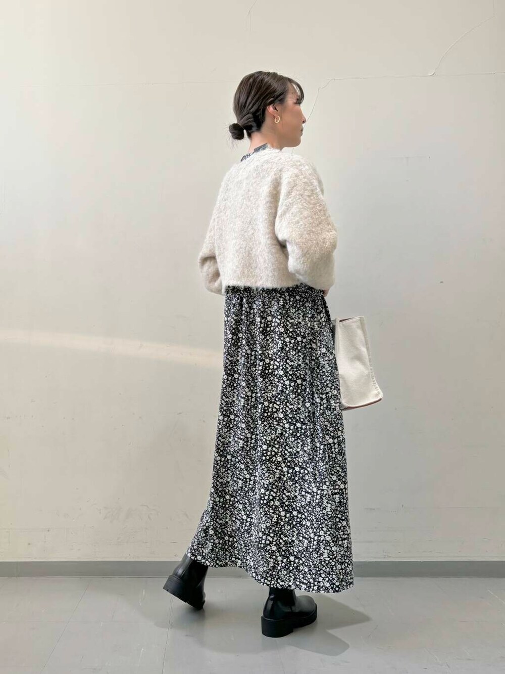 ブラック系のブーツ、ベージュ系のトートバッグ、ブラック系のワンピースを着用したレディースの秋コーディネートの3枚目の写真