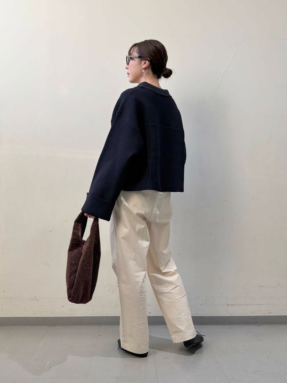 ブラック系のその他シューズ、ブラウン系のトートバッグ、ホワイト系のその他パンツを着用したレディースの冬コーディネートの4枚目の写真