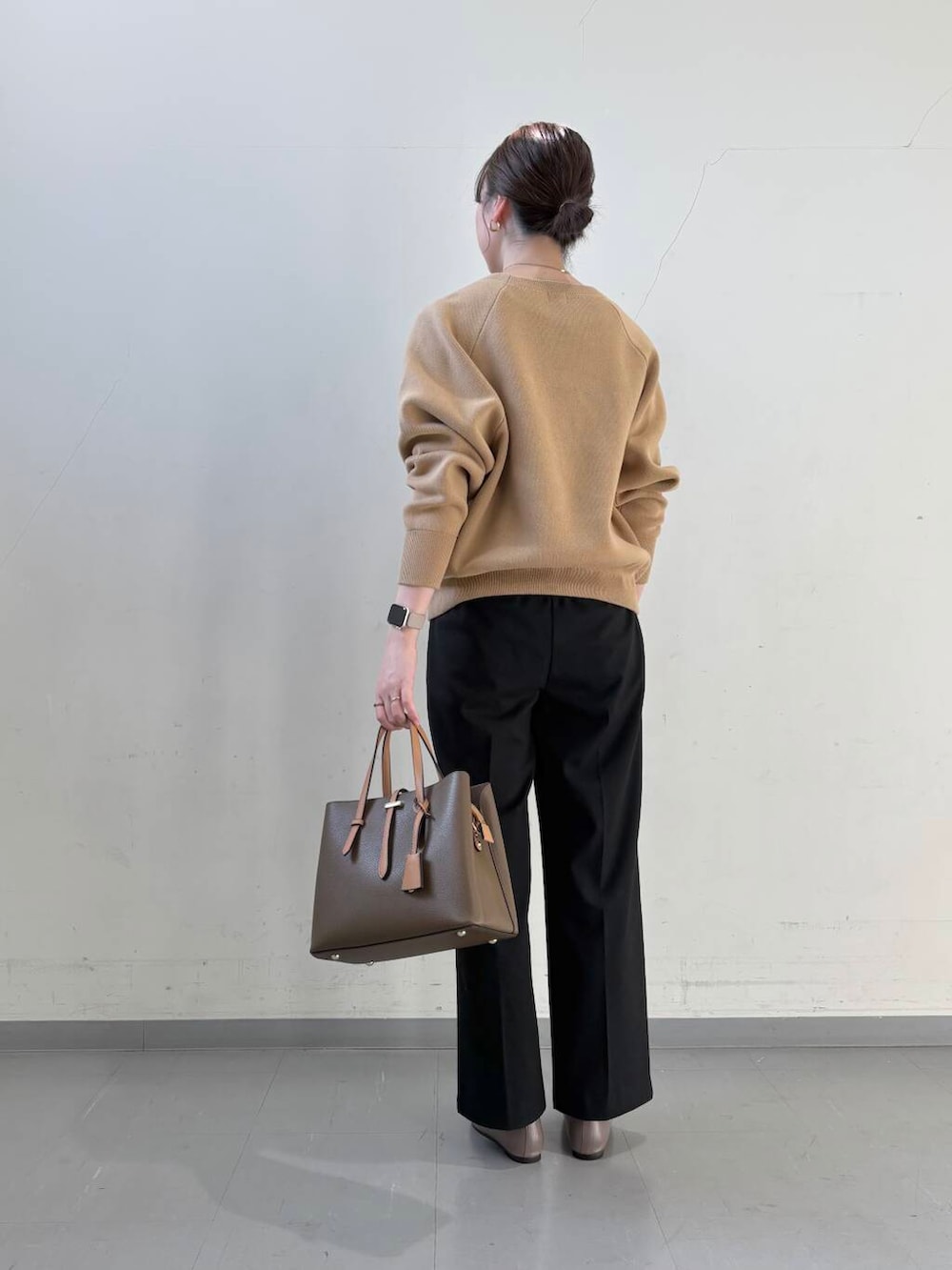 ベージュ系のパンプス、ブラウン系のハンドバッグ、ベージュ系のニット/セーターを着用したレディースの冬コーディネートの7枚目の写真