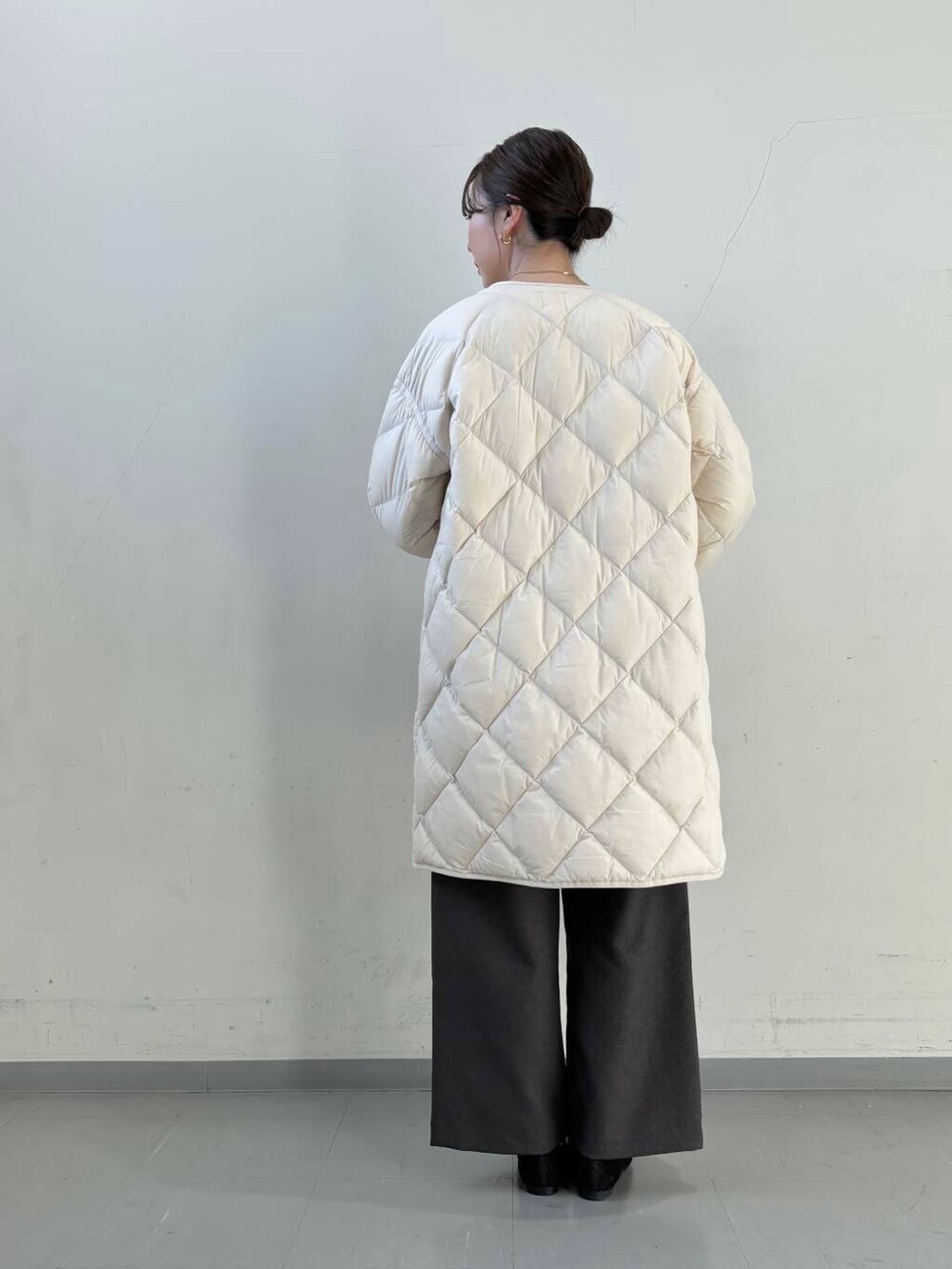 ホワイト系のダウンジャケット/コート、ブラック系のショルダーバッグ、ブラック系のローファーを着用したレディースの冬コーディネートの10枚目の写真