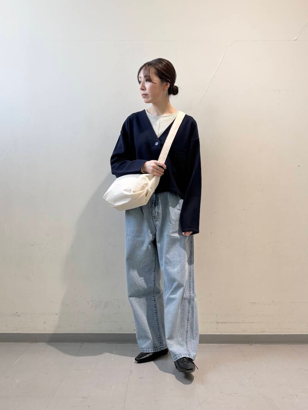 ホワイト系のショルダーバッグ、ブラック系のその他シューズ、ブルー系のデニムパンツを着用したレディースの冬コーディネートの2枚目の写真