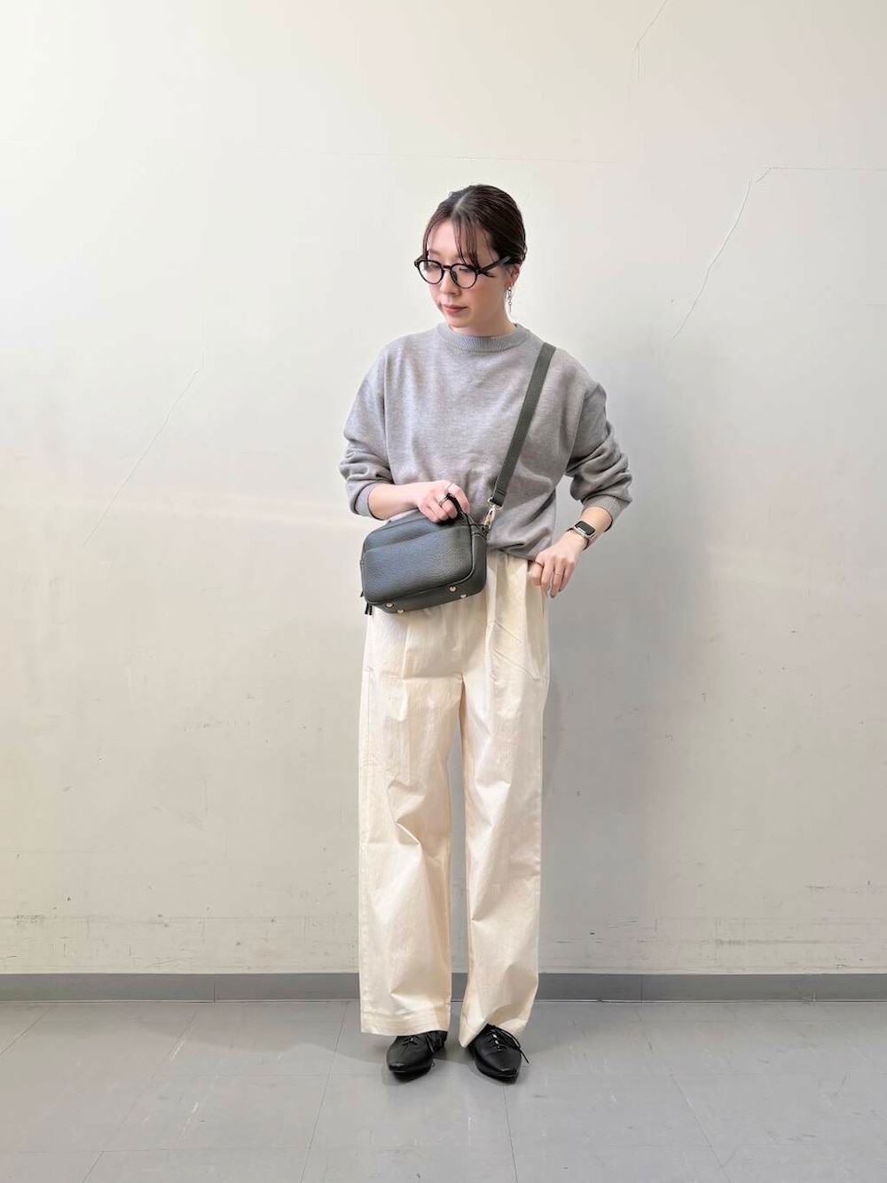 グリーン系のショルダーバッグ、ブラック系のその他シューズ、ホワイト系のその他パンツを着用したレディースの冬コーディネートの2枚目の写真