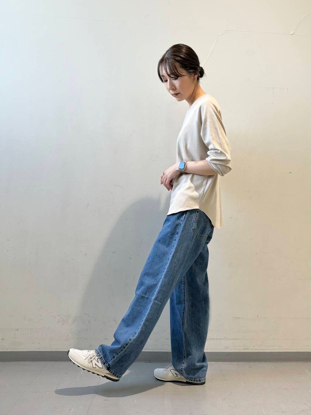 ブルー系のデニムパンツ、ホワイト系のスニーカー、イエロー系のカーディガン/ボレロを着用したレディースの秋コーディネートの7枚目の写真