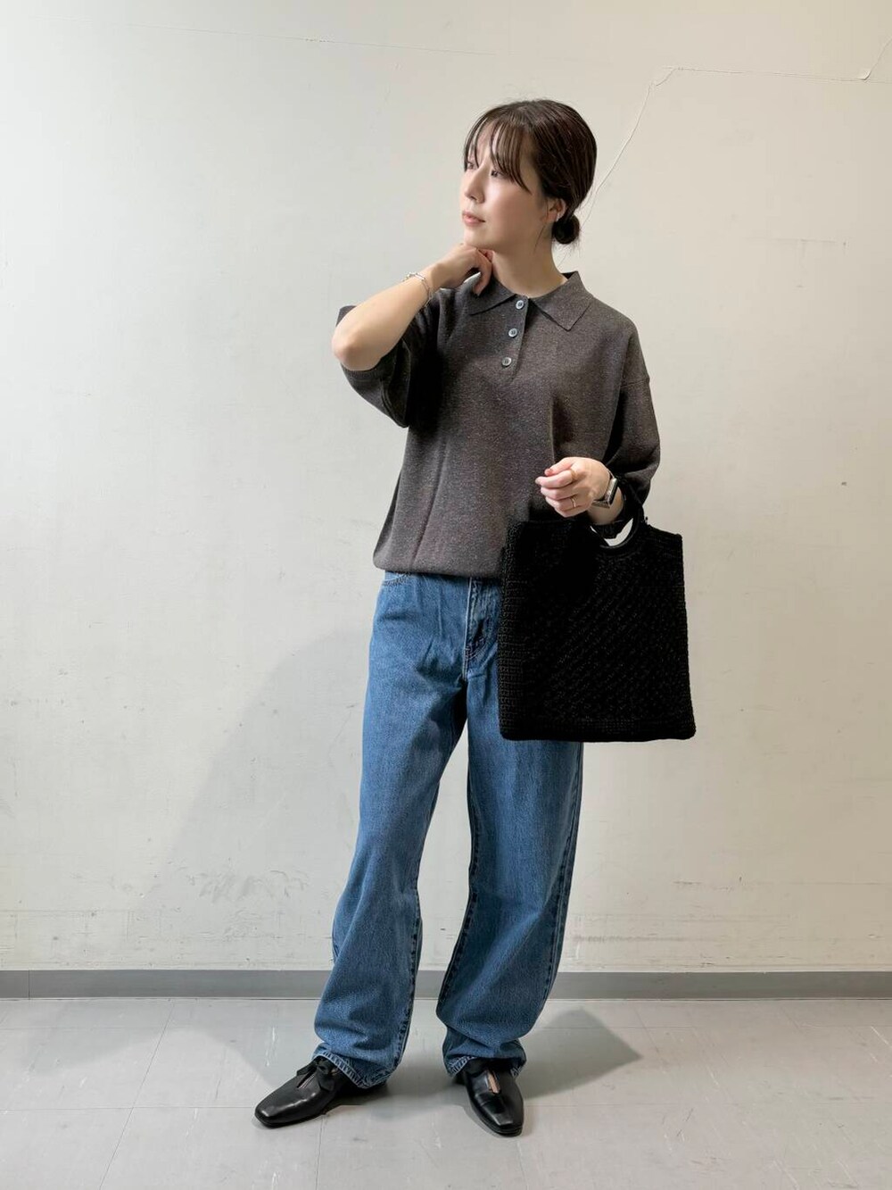 ブルー系のデニムパンツ、ブラック系のトートバッグ、グレー系のニット/セーターを着用したレディースの夏コーディネートの2枚目の写真