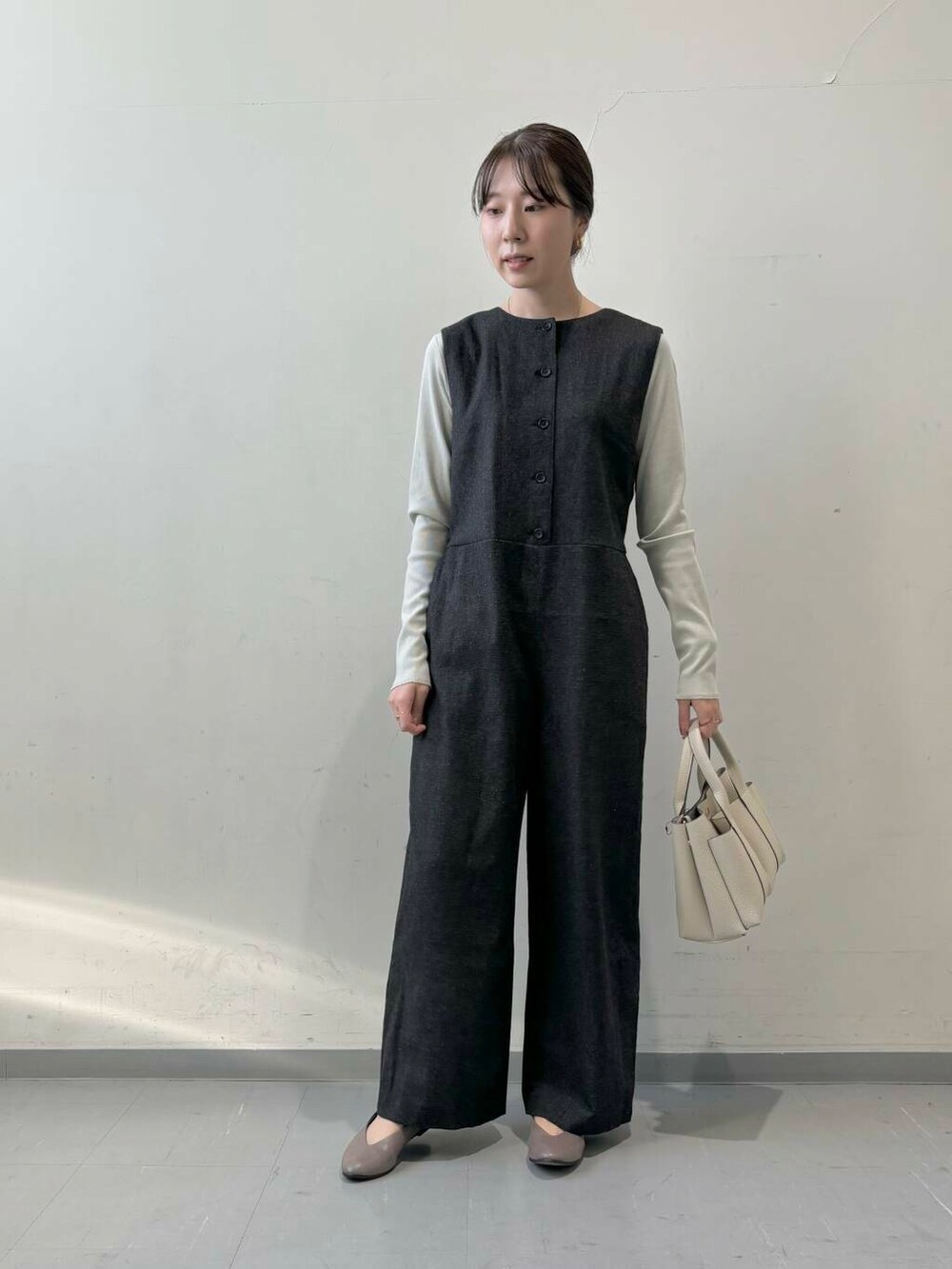 ホワイト系のトートバッグ、ベージュ系のパンプス、グレー系のTシャツ/カットソーを着用したレディースの秋コーディネートの3枚目の写真