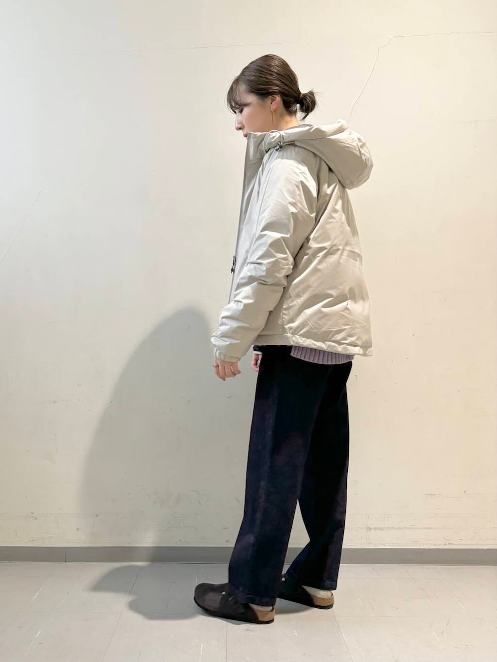 ブルー系のデニムパンツ、パープル系のニット/セーター、ホワイト系のダウンジャケット/コートを着用したレディースの秋コーディネートの2枚目の写真
