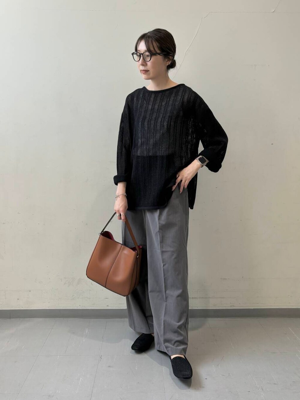 ブラウン系のハンドバッグ、グレー系のその他パンツ、ブラック系のニット/セーターを着用したレディースの夏コーディネートの2枚目の写真