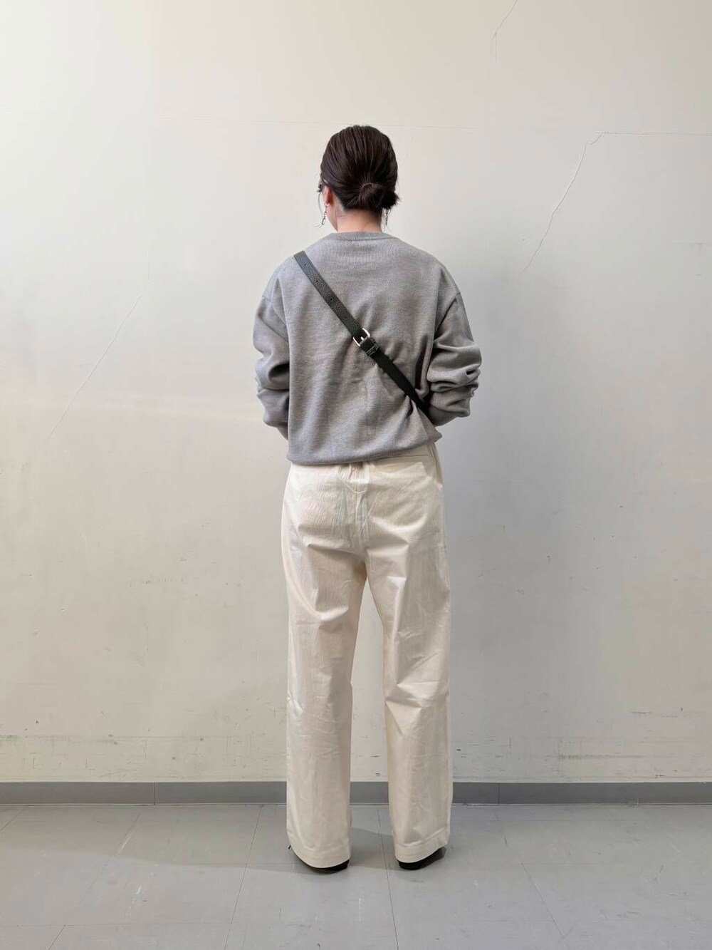 グリーン系のショルダーバッグ、ブラック系のその他シューズ、ホワイト系のその他パンツを着用したレディースの冬コーディネートの4枚目の写真