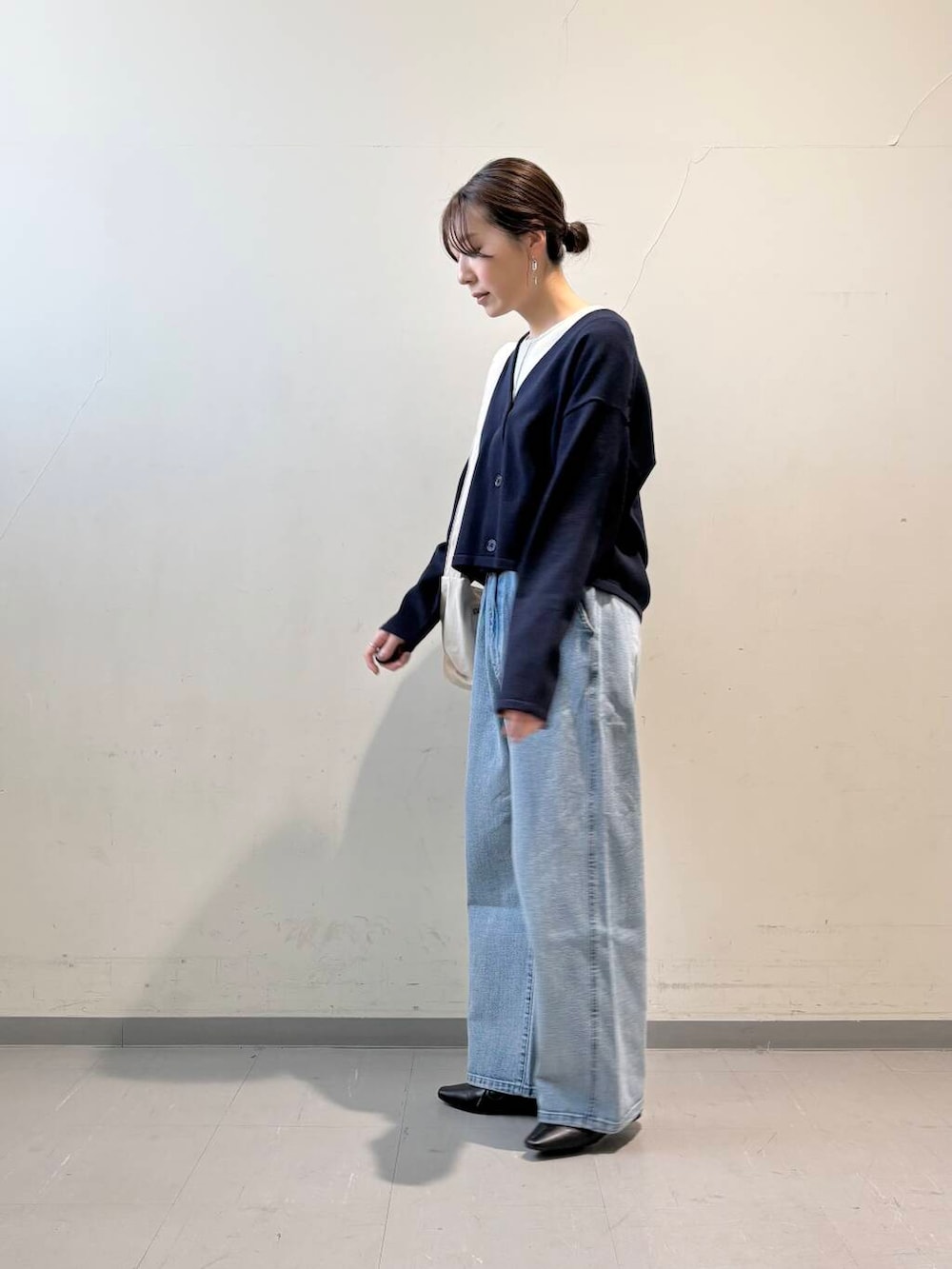 ホワイト系のショルダーバッグ、ブラック系のその他シューズ、ブルー系のデニムパンツを着用したレディースの冬コーディネートの3枚目の写真