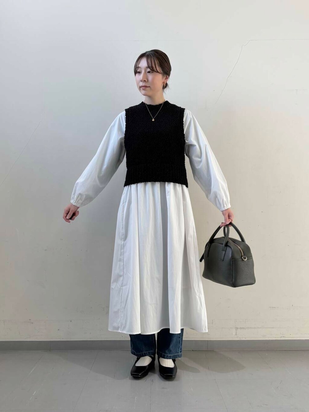 ブルー系のデニムパンツ、ブラック系のボストンバッグ、ブラック系のパンプスを着用したレディースの冬コーディネートの4枚目の写真