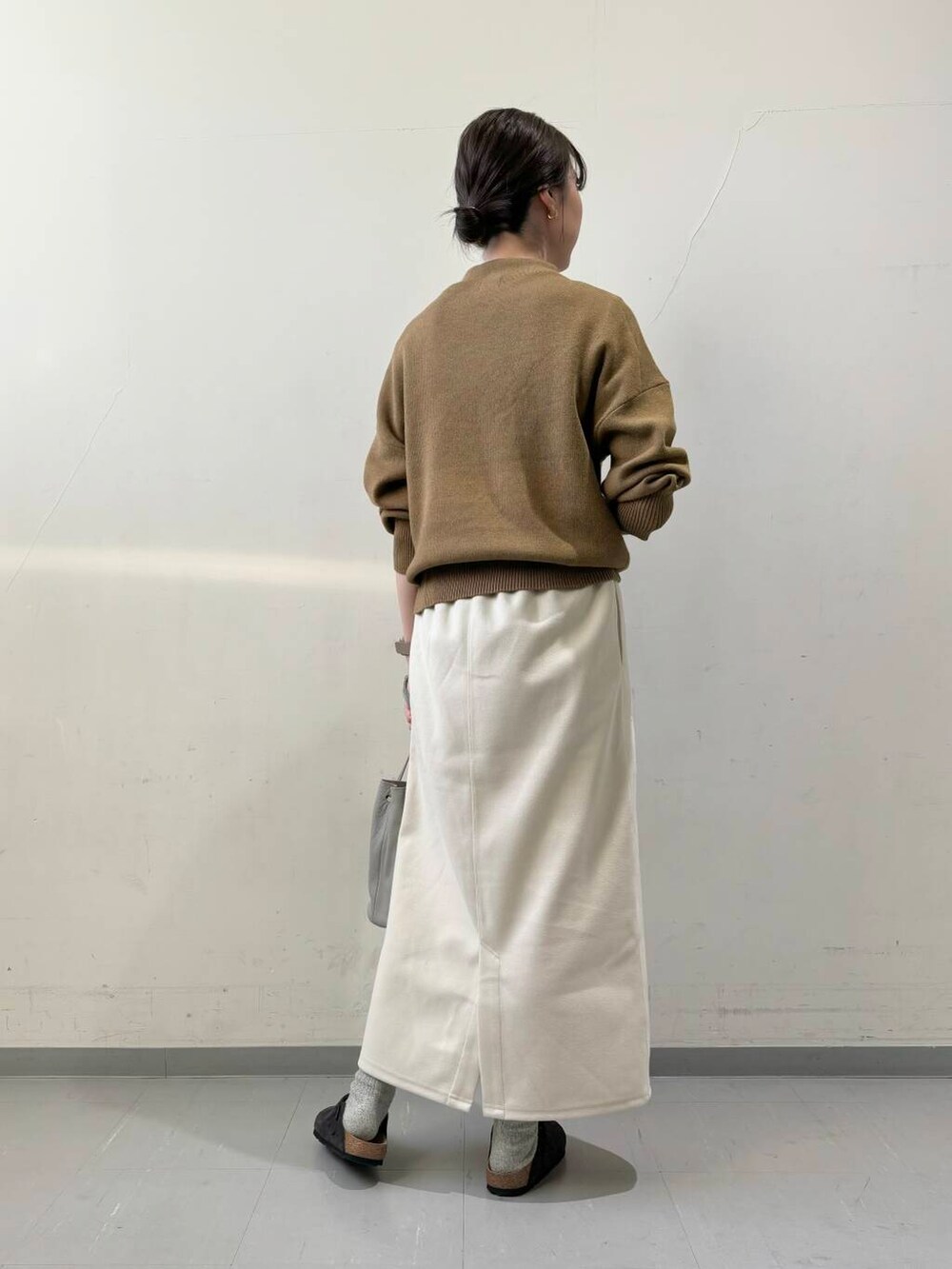 ブラック系のダウンジャケット/コート、グレー系のショルダーバッグ、グリーン系のニット/セーターを着用したレディースの秋コーディネートの7枚目の写真