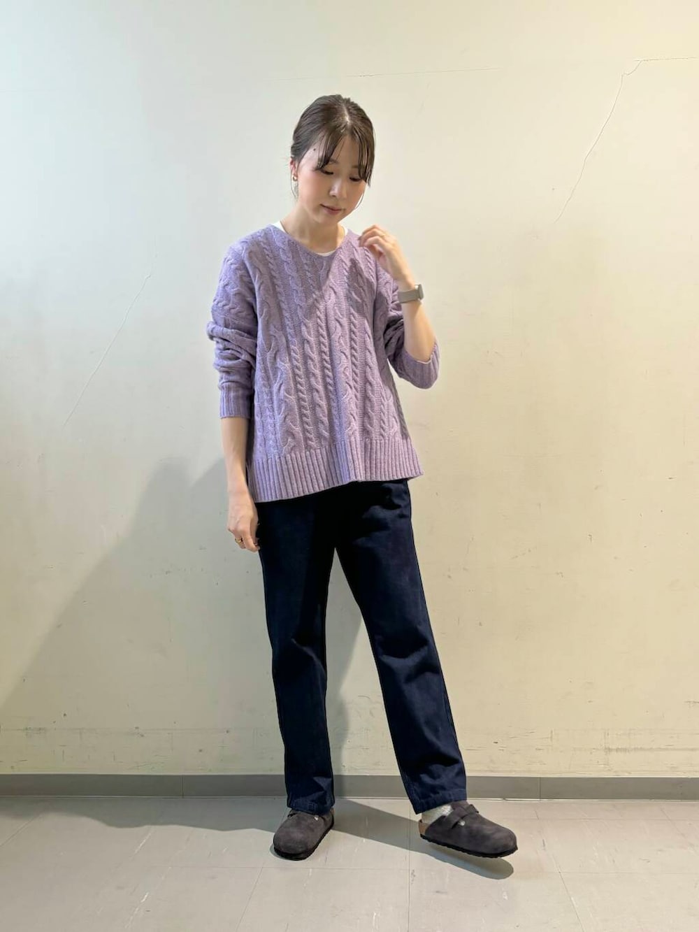 ブルー系のデニムパンツ、パープル系のニット/セーター、ホワイト系のダウンジャケット/コートを着用したレディースの秋コーディネートの5枚目の写真