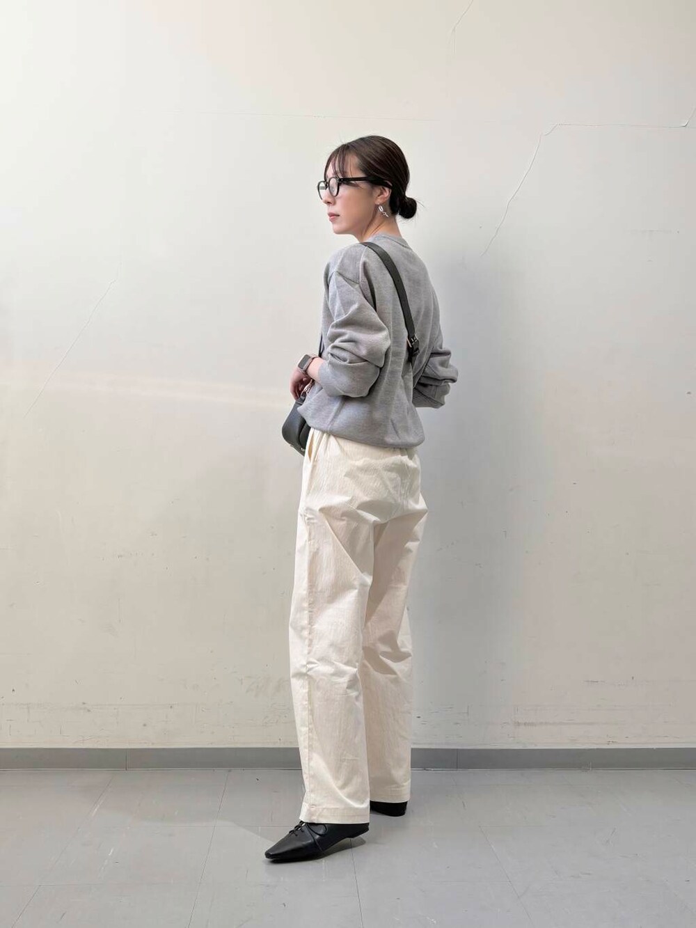 グリーン系のショルダーバッグ、ブラック系のその他シューズ、ホワイト系のその他パンツを着用したレディースの冬コーディネートの3枚目の写真