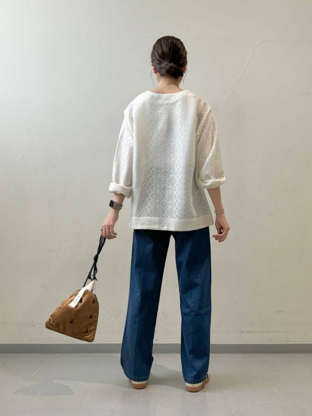 ホワイト系のタンクトップ、ブラウン系のショルダーバッグ、ベージュ系のスニーカーを着用したレディースの夏コーディネートの4枚目の写真