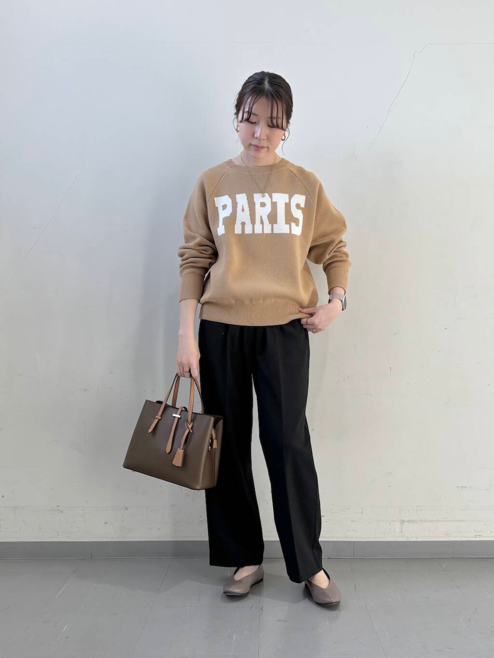 ベージュ系のパンプス、ブラウン系のハンドバッグ、ベージュ系のニット/セーターを着用したレディースの冬コーディネートの5枚目の写真