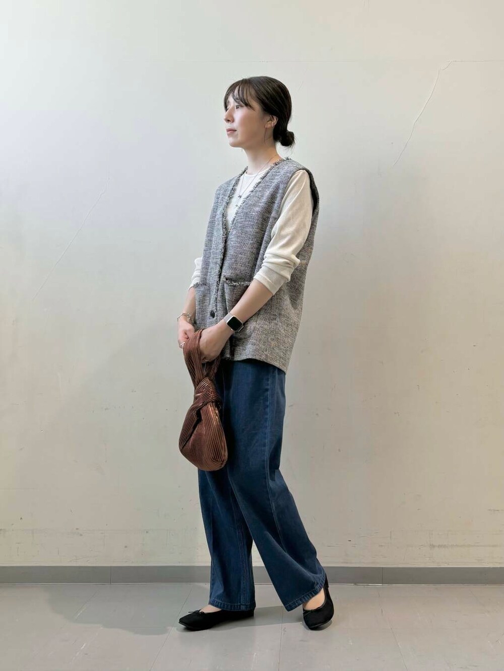 ブラウン系のハンドバッグ、ブラック系のバレエシューズ、ホワイト系のTシャツ/カットソーを着用したレディースの秋コーディネートの3枚目の写真