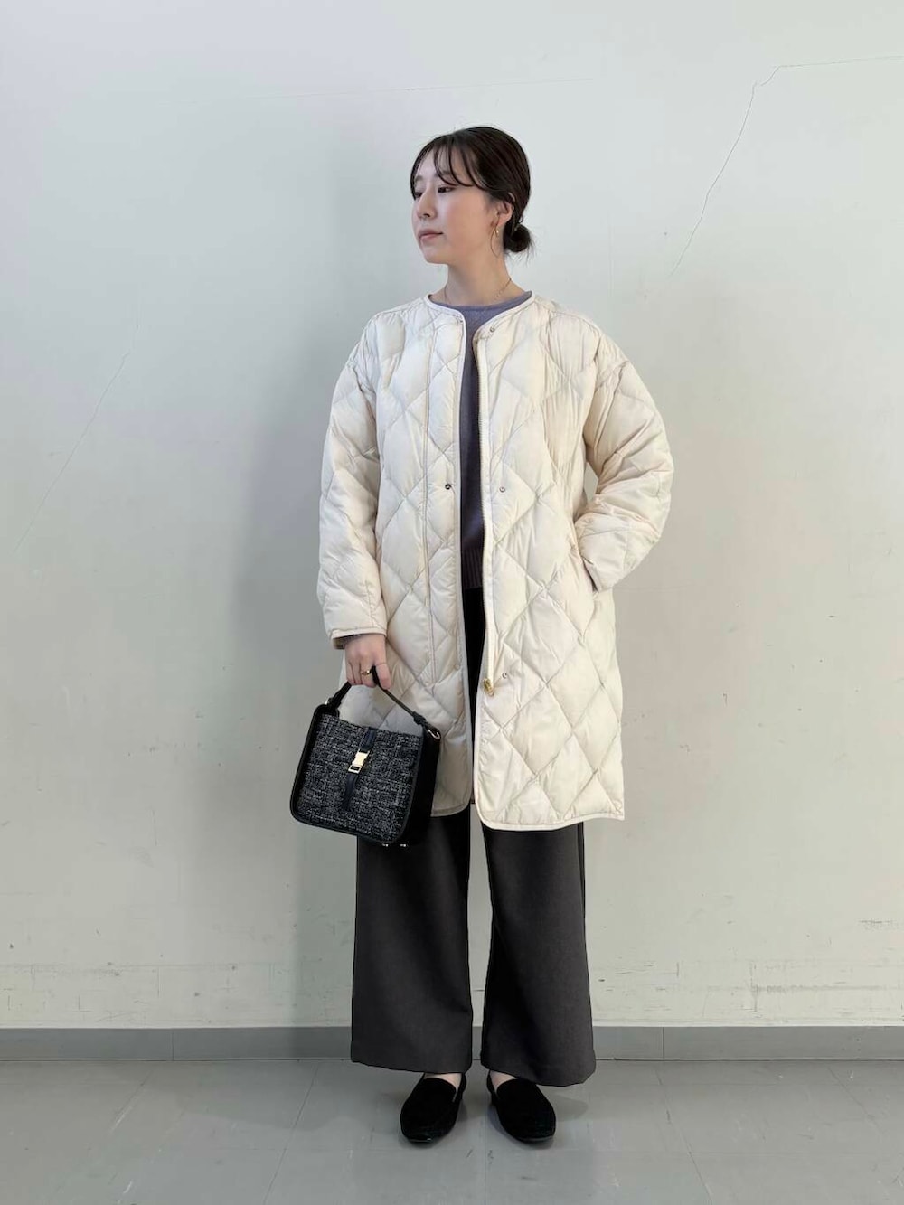 ホワイト系のダウンジャケット/コート、ブラック系のショルダーバッグ、ブラック系のローファーを着用したレディースの冬コーディネートの7枚目の写真