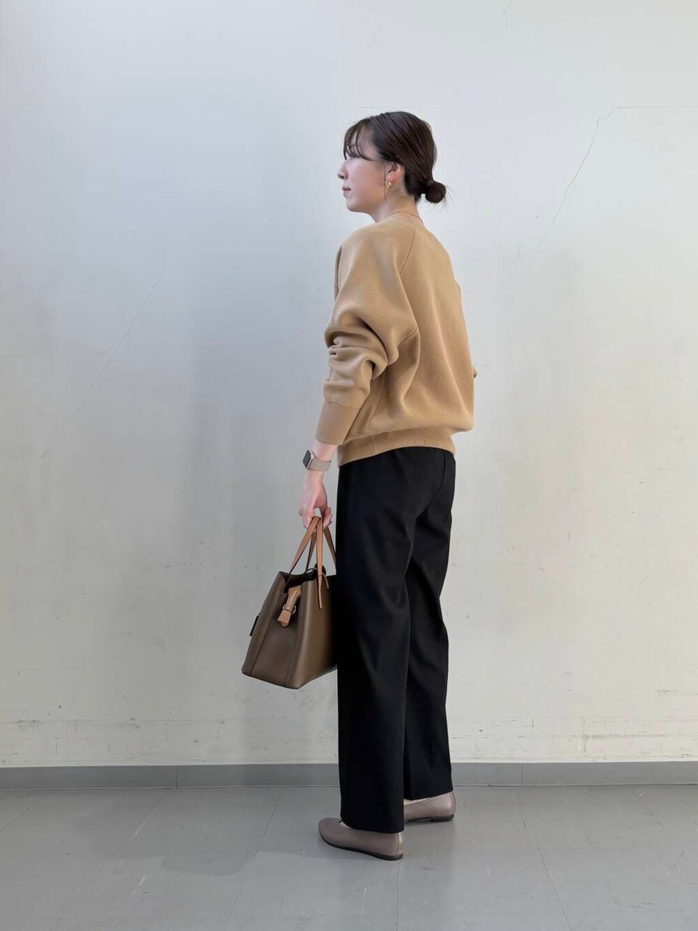 ベージュ系のパンプス、ブラウン系のハンドバッグ、ベージュ系のニット/セーターを着用したレディースの冬コーディネートの6枚目の写真