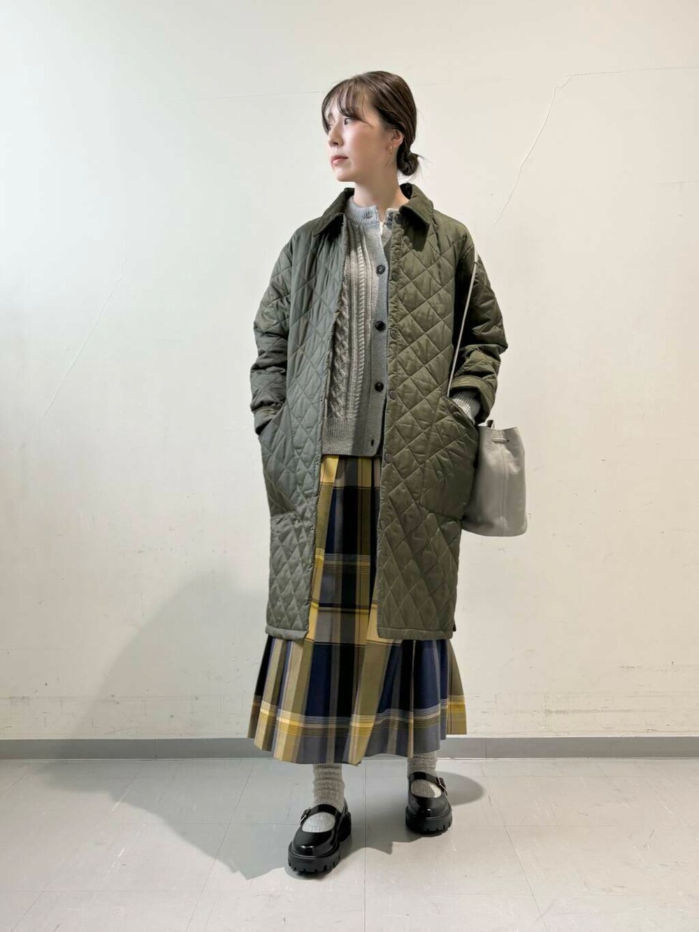 グレー系のカーディガン/ボレロ、グレー系のショルダーバッグ、ブルー系のスカートを着用したレディースの秋コーディネートの2枚目の写真