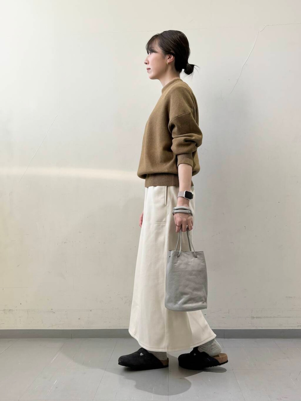 ブラック系のダウンジャケット/コート、グレー系のショルダーバッグ、グリーン系のニット/セーターを着用したレディースの秋コーディネートの8枚目の写真