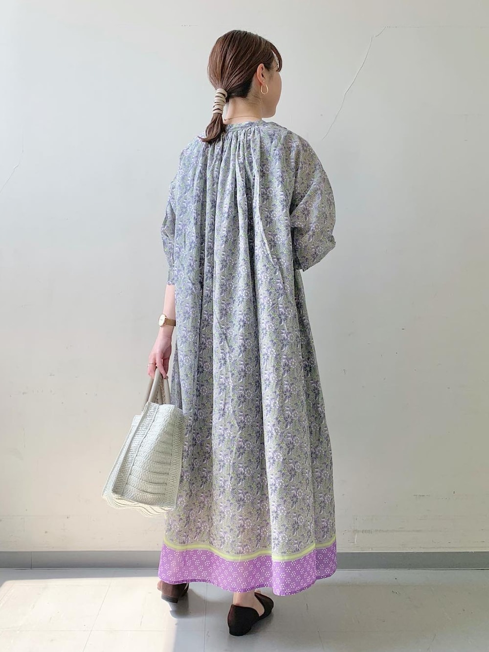 パープル系のワンピース/ドレス、ホワイト系のトートバッグ、ブラウン系のサンダルを着用したレディースの春コーディネートの2枚目の写真