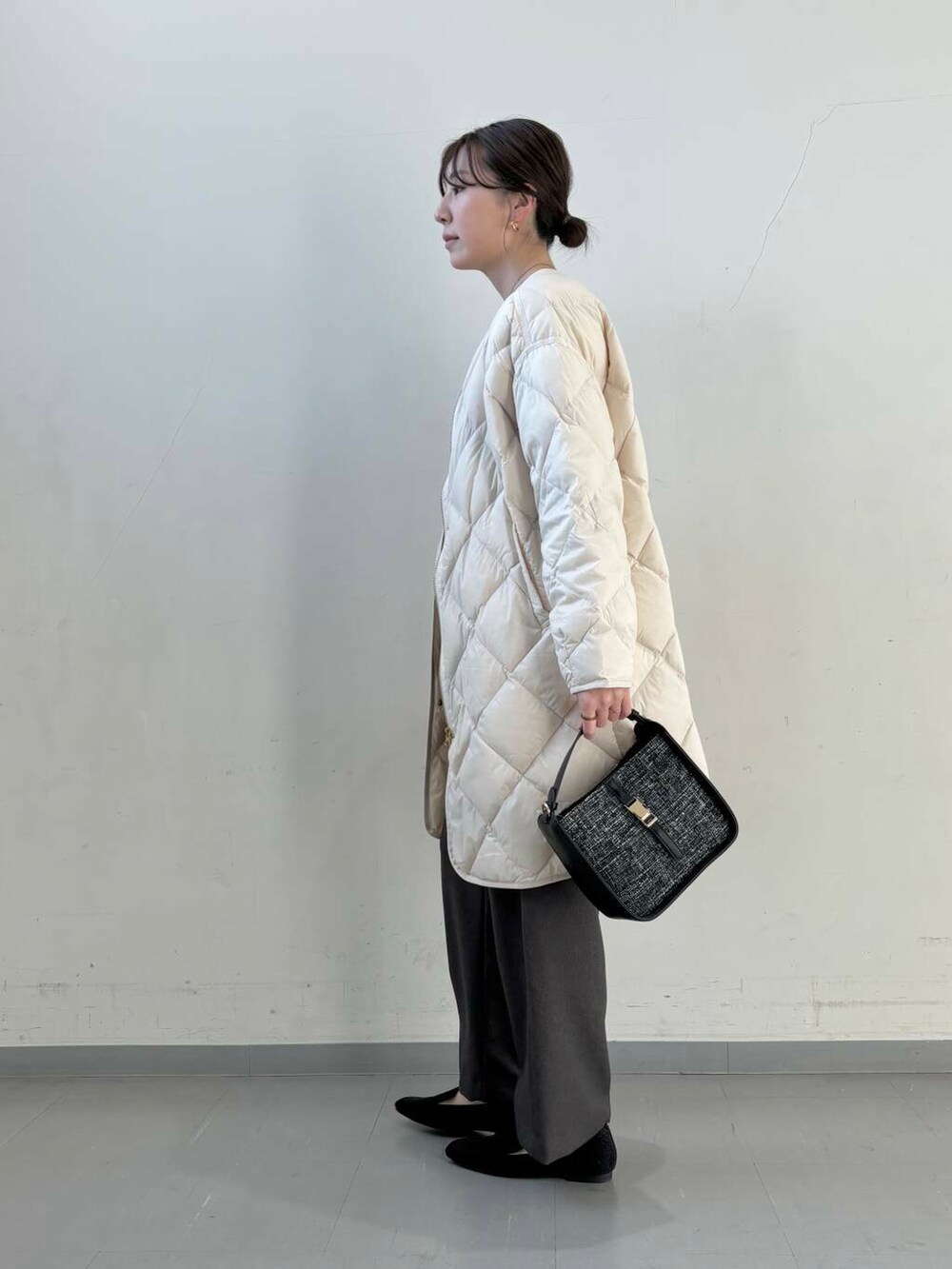 ホワイト系のダウンジャケット/コート、ブラック系のショルダーバッグ、ブラック系のローファーを着用したレディースの冬コーディネートの8枚目の写真