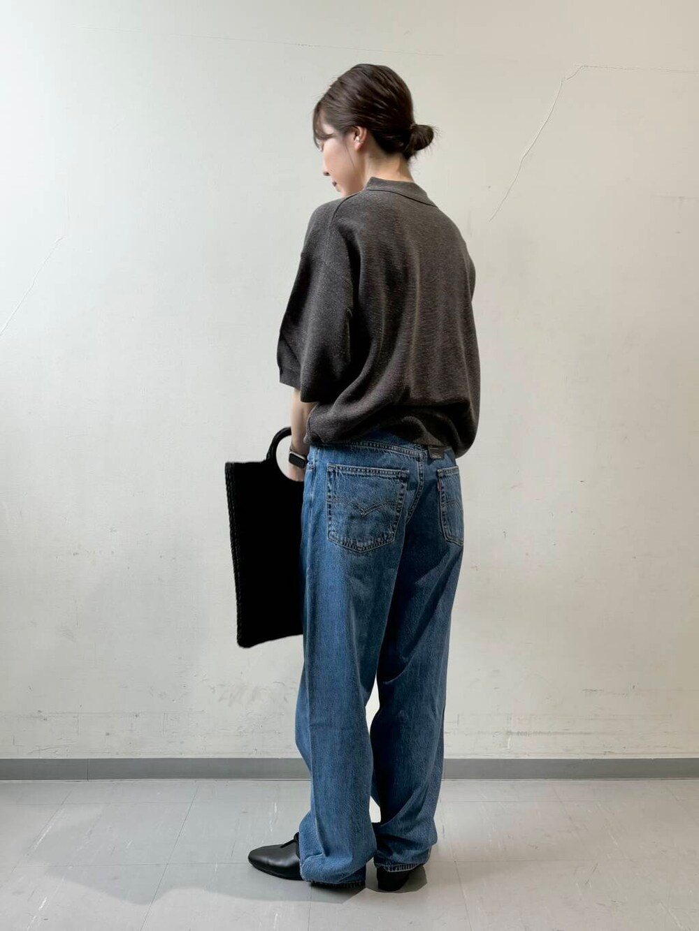 ブルー系のデニムパンツ、ブラック系のトートバッグ、グレー系のニット/セーターを着用したレディースの夏コーディネートの5枚目の写真