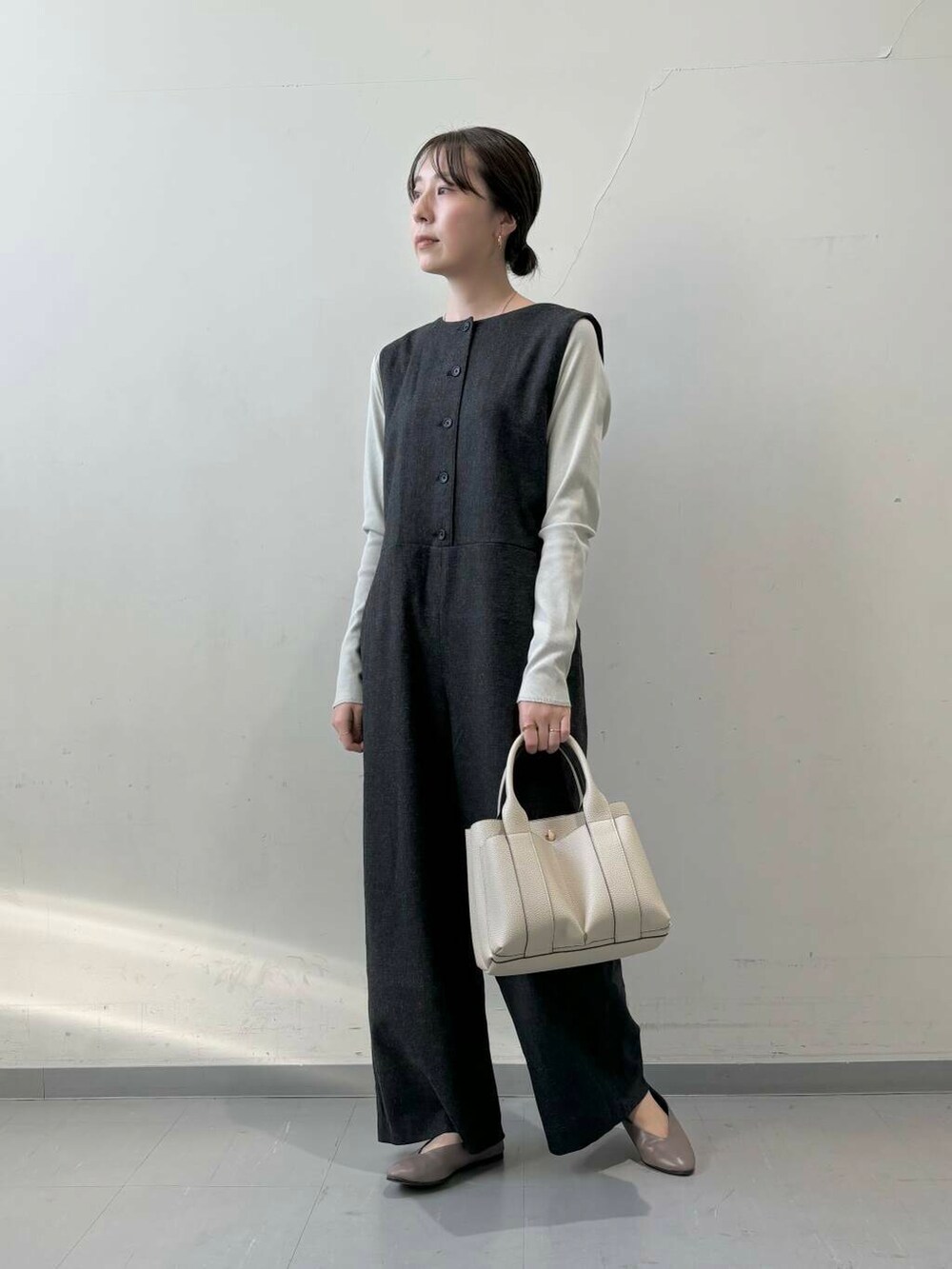 ホワイト系のトートバッグ、ベージュ系のパンプス、グレー系のTシャツ/カットソーを着用したレディースの秋コーディネートの2枚目の写真