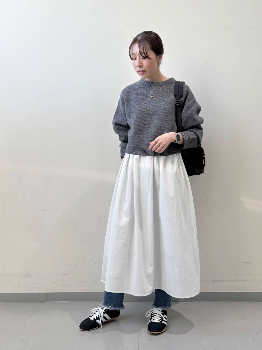 ブラック系のバックパック/リュック、グレー系のニット/セーター、グレー系のワンピースを着用したレディースの冬コーディネートの2枚目の写真