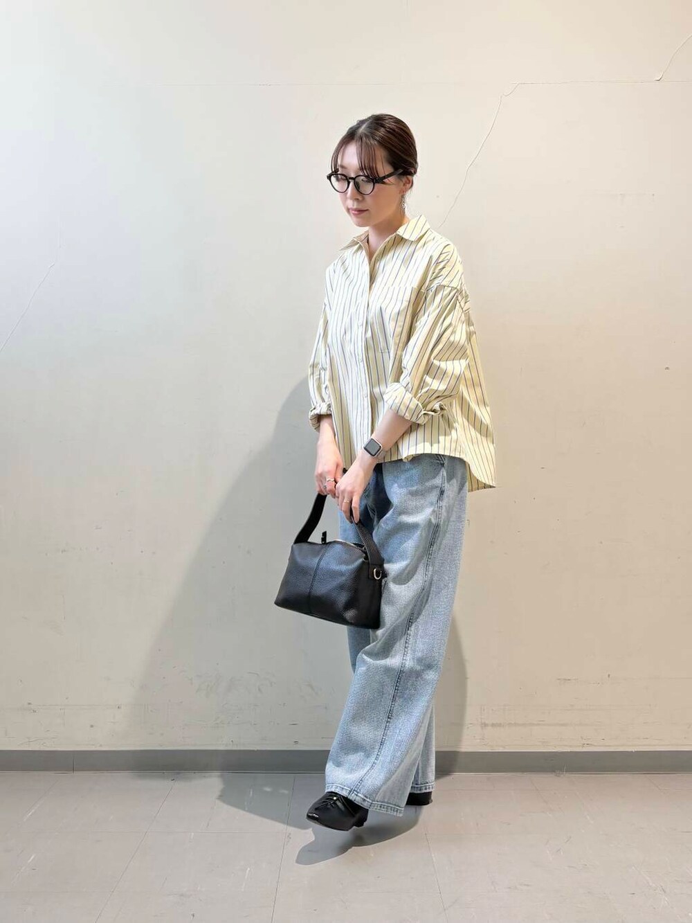 ブラック系のその他シューズ、ブルー系のデニムパンツ、イエロー系のシャツ/ブラウスを着用したレディースの冬コーディネートの2枚目の写真