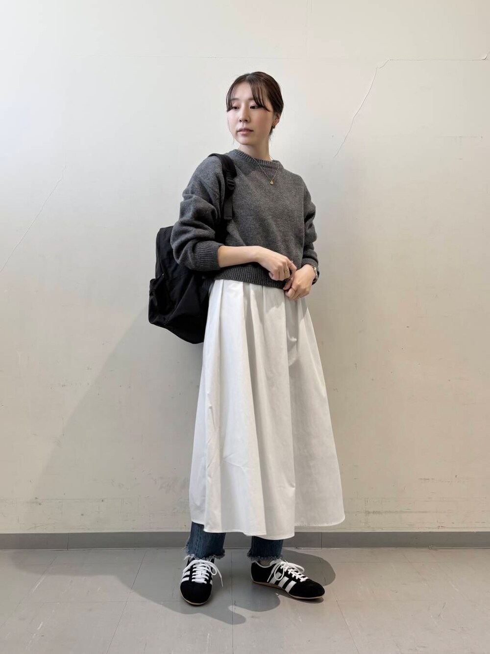 ブラック系のバックパック/リュック、グレー系のニット/セーター、グレー系のワンピースを着用したレディースの冬コーディネートの3枚目の写真