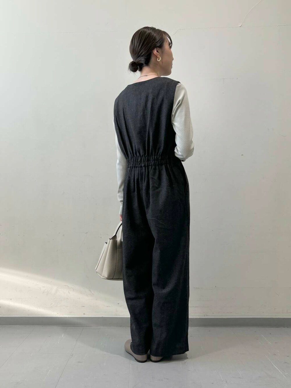 ホワイト系のトートバッグ、ベージュ系のパンプス、グレー系のTシャツ/カットソーを着用したレディースの秋コーディネートの5枚目の写真