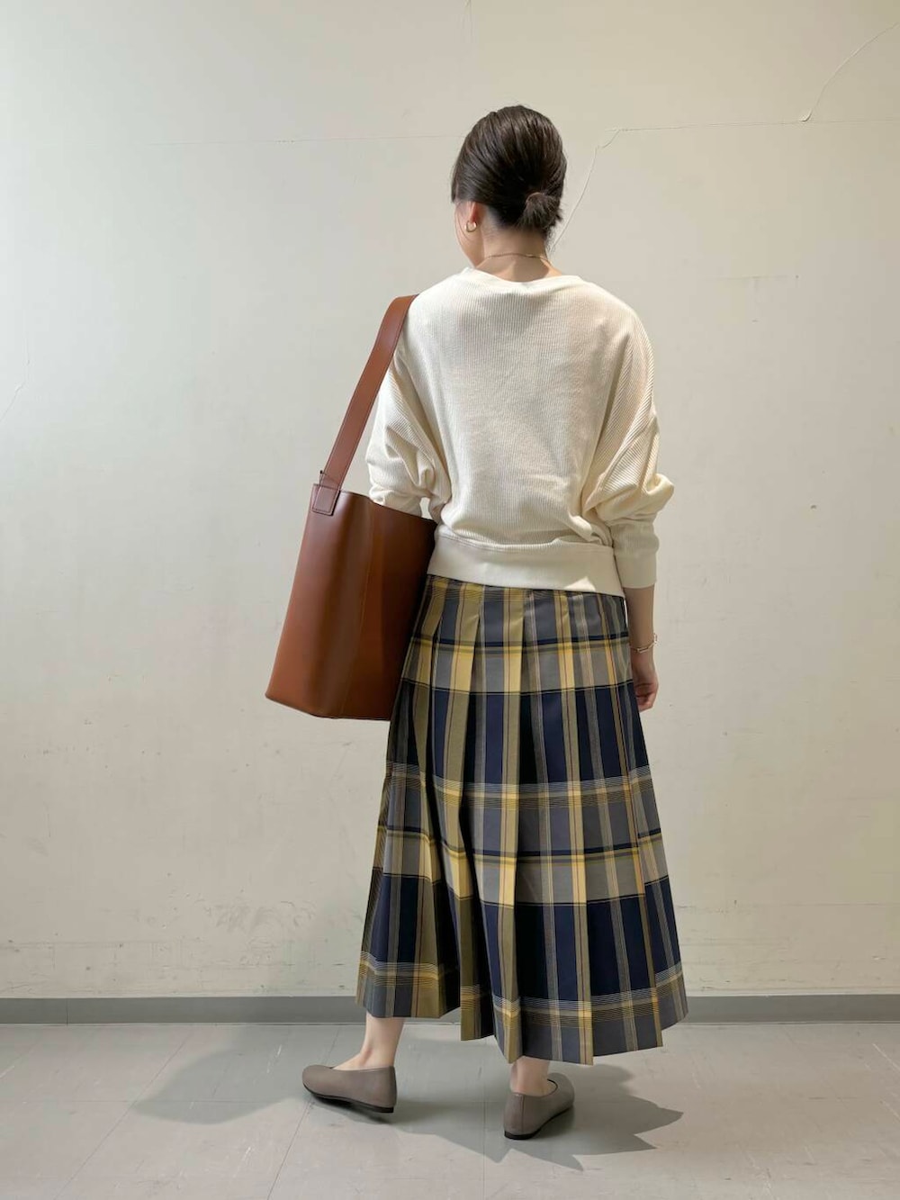 ベージュ系のパンプス、ベージュ系のTシャツ/カットソー、ブラウン系のトートバッグを着用したレディースの秋コーディネートの4枚目の写真