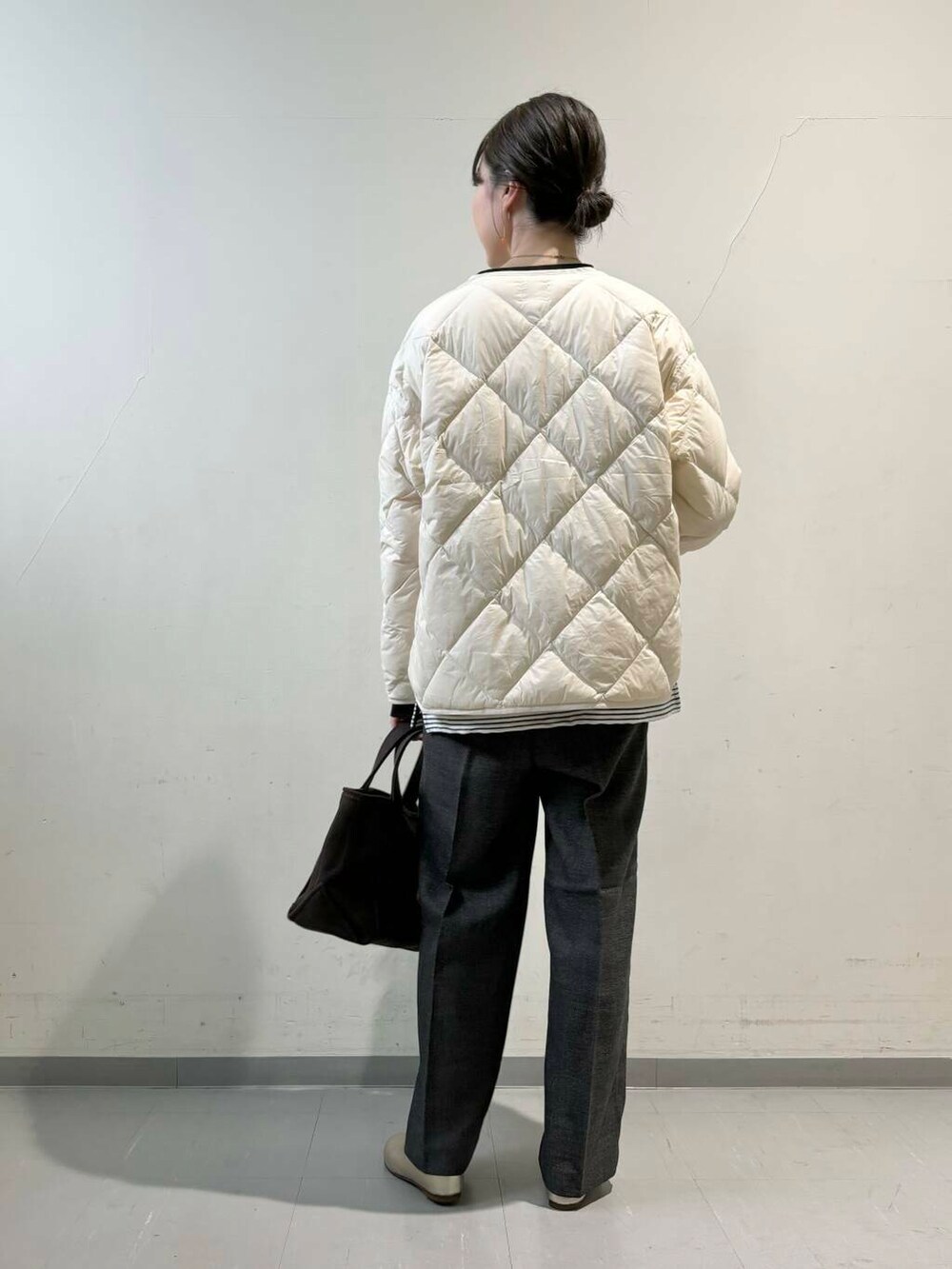 ホワイト系のダウンジャケット/コート、ゴールド系のパンプス、グレー系のその他パンツを着用したレディースの秋コーディネートの3枚目の写真