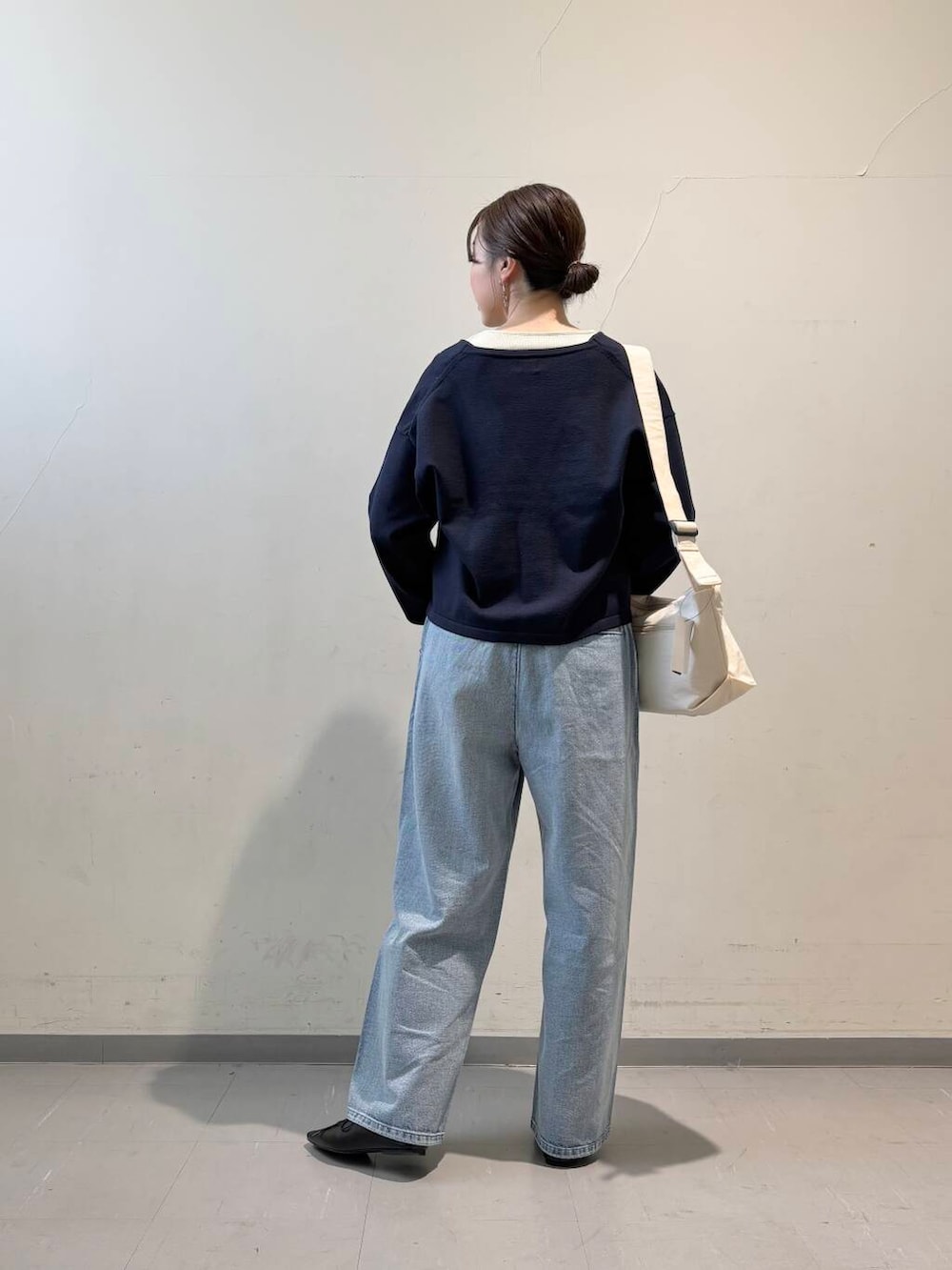 ホワイト系のショルダーバッグ、ブラック系のその他シューズ、ブルー系のデニムパンツを着用したレディースの冬コーディネートの4枚目の写真