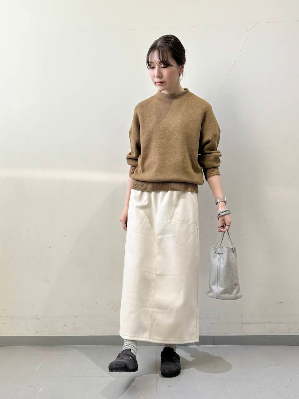 ブラック系のダウンジャケット/コート、グレー系のショルダーバッグ、グリーン系のニット/セーターを着用したレディースの秋コーディネートの6枚目の写真