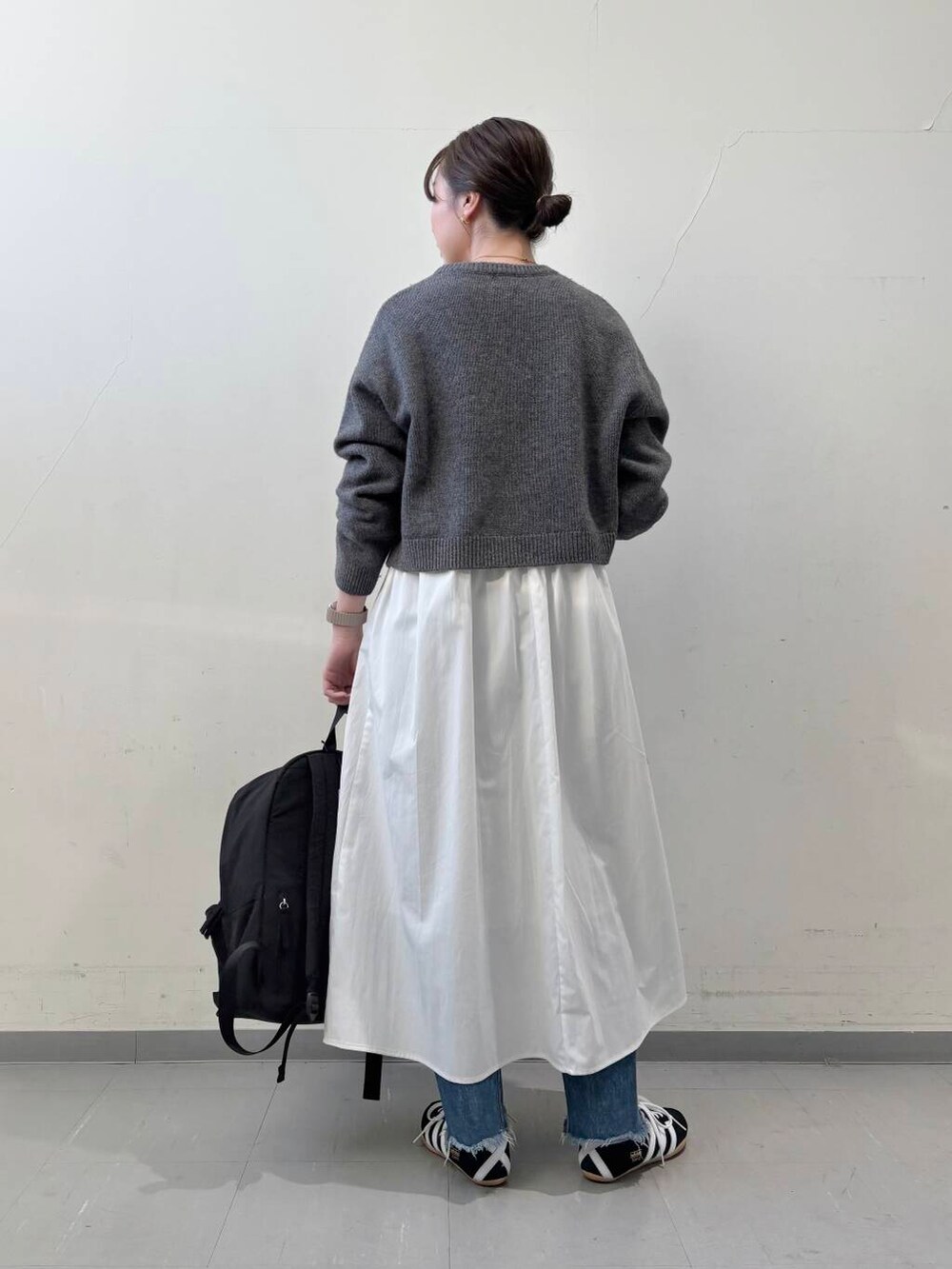 ブラック系のバックパック/リュック、グレー系のニット/セーター、グレー系のワンピースを着用したレディースの冬コーディネートの6枚目の写真