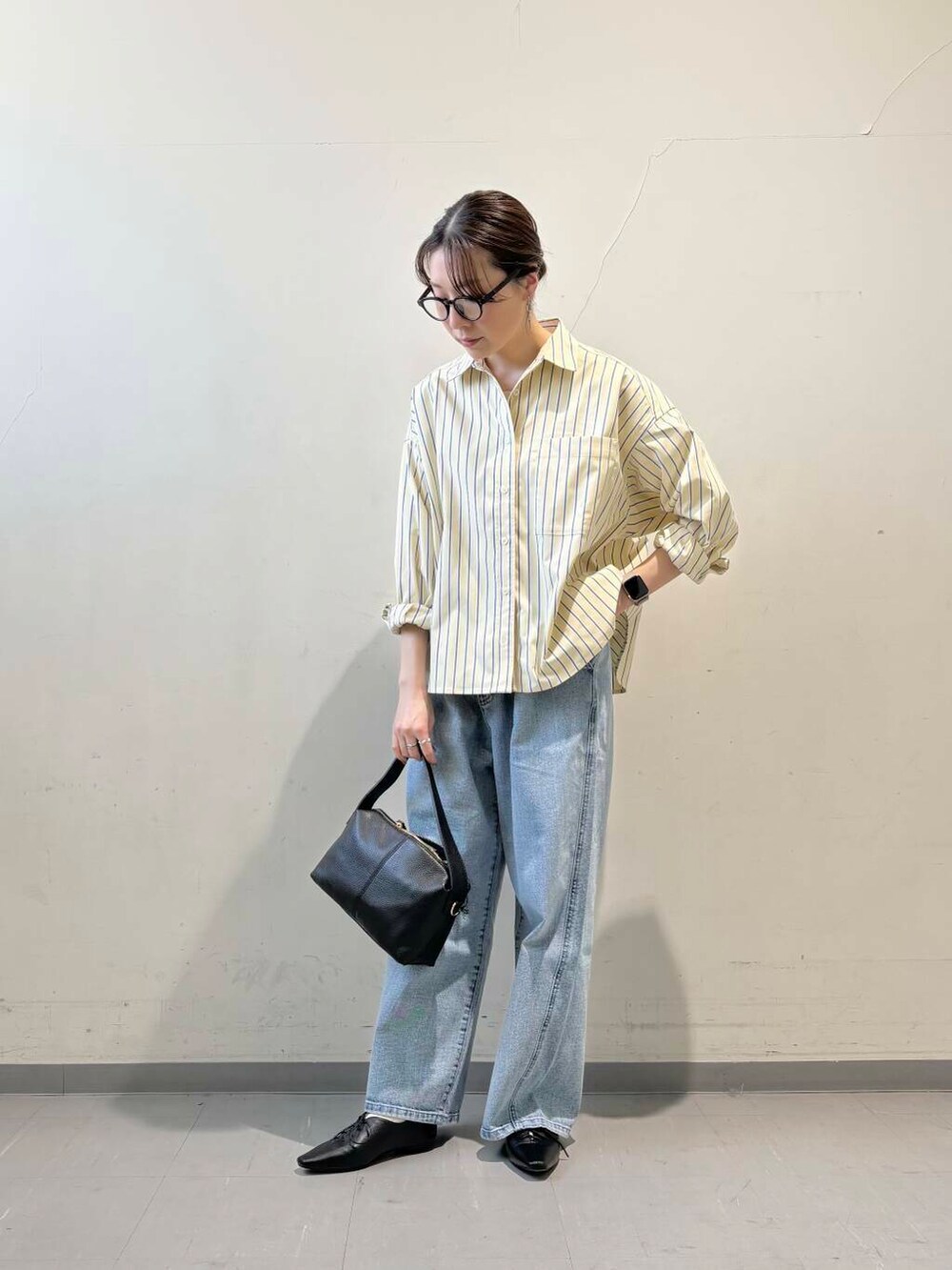 ブラック系のその他シューズ、ブルー系のデニムパンツ、イエロー系のシャツ/ブラウスを着用したレディースの冬コーディネートの3枚目の写真