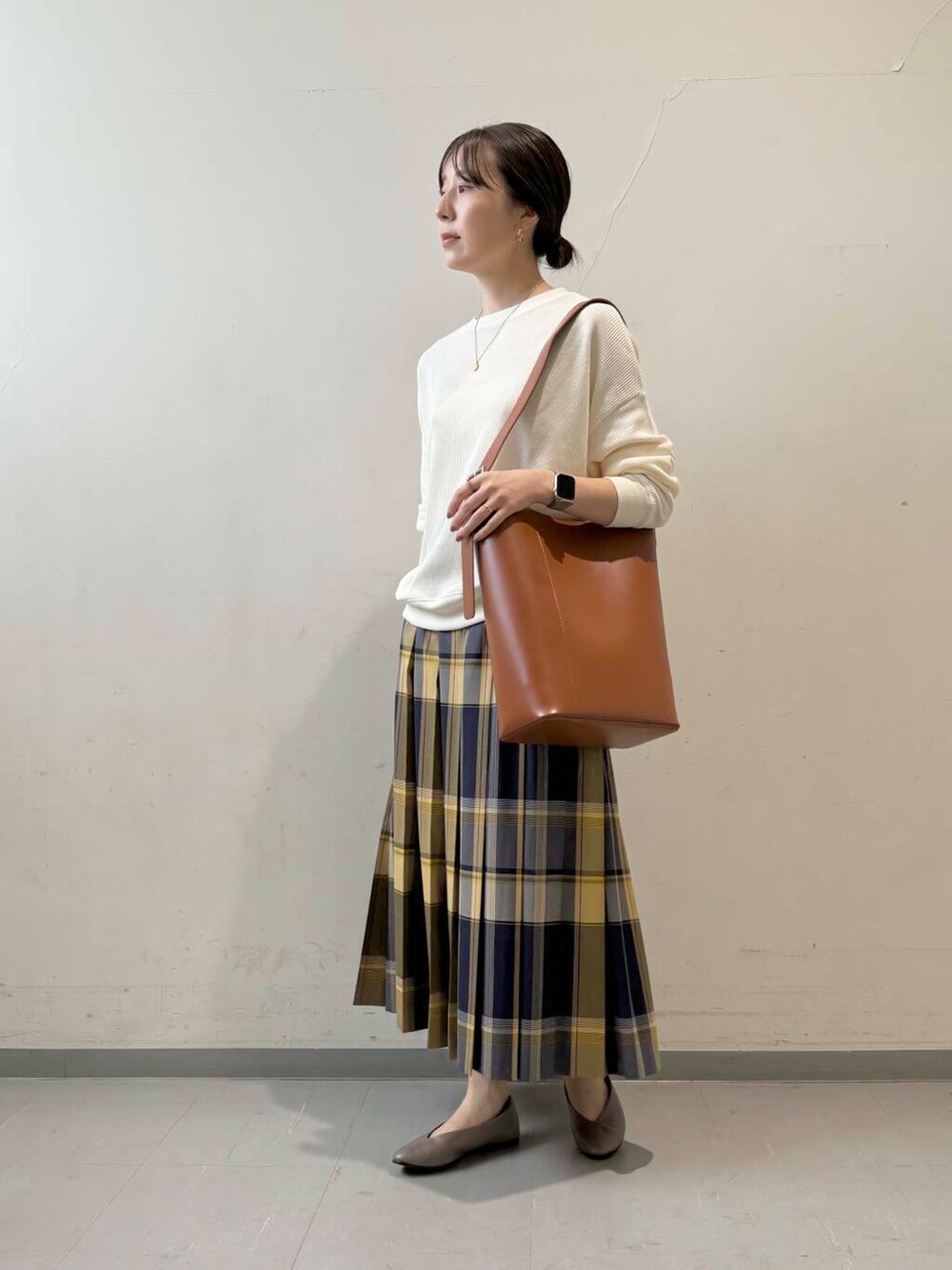 ベージュ系のパンプス、ベージュ系のTシャツ/カットソー、ブラウン系のトートバッグを着用したレディースの秋コーディネートの2枚目の写真