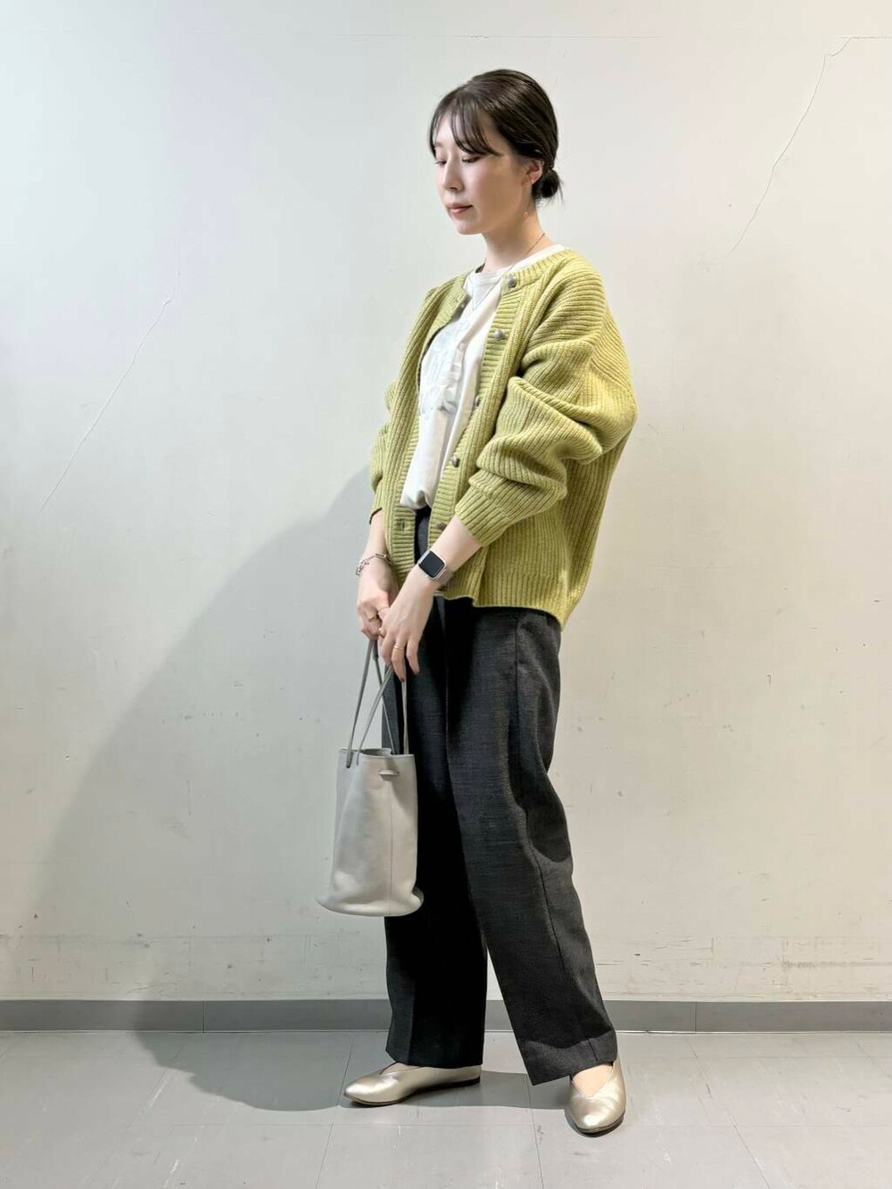 ゴールド系のパンプス、グレー系のショルダーバッグ、グリーン系のカーディガン/ボレロを着用したレディースの秋コーディネートの2枚目の写真