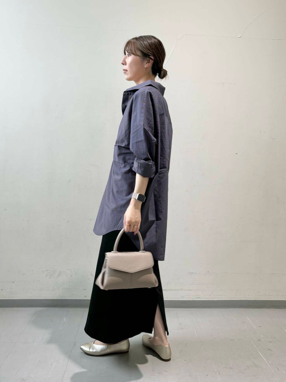 ベージュ系のタンクトップ、ブラック系のスカート、ゴールド系のパンプスを着用したレディースの夏コーディネートの3枚目の写真