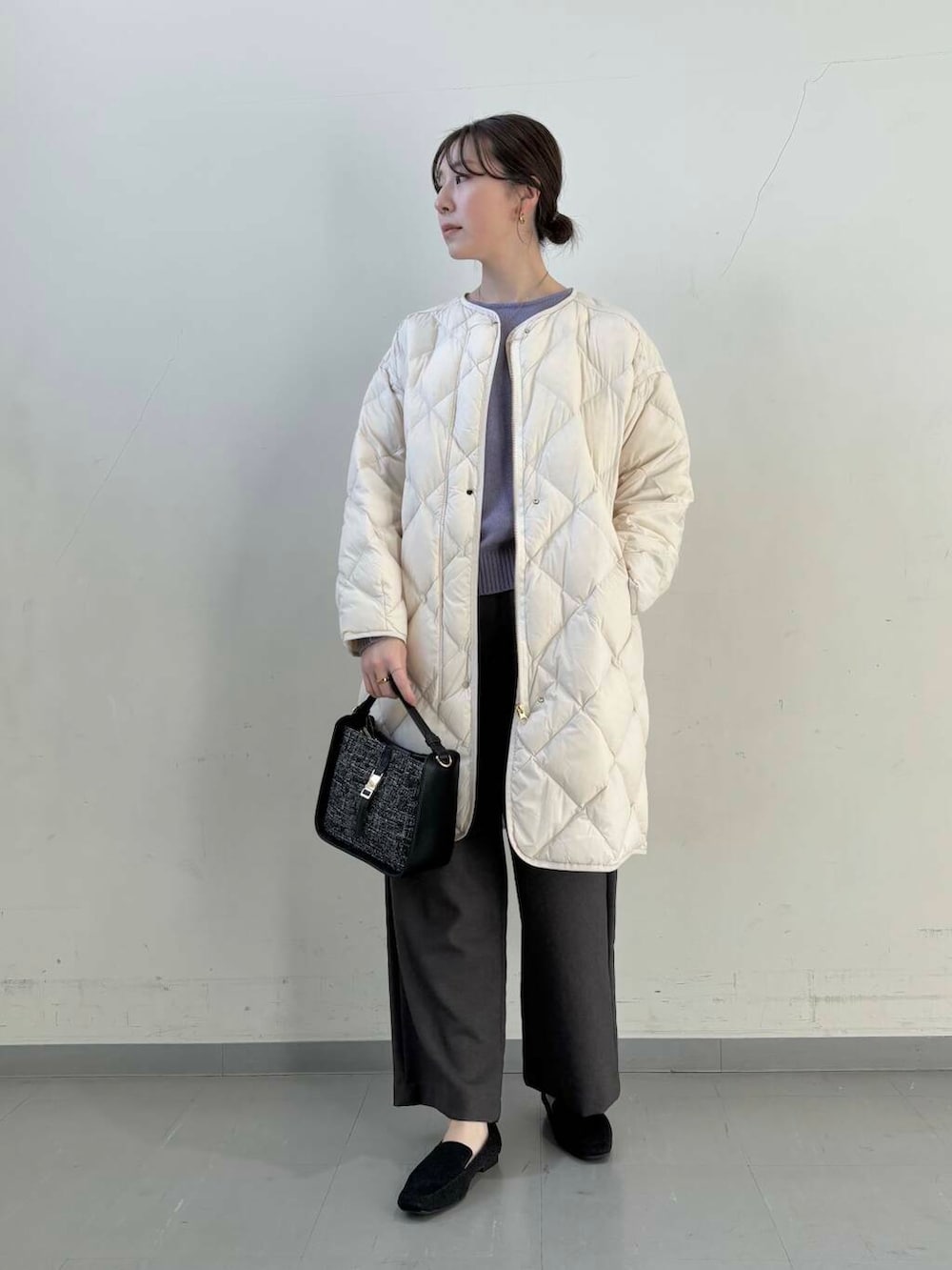 ホワイト系のダウンジャケット/コート、ブラック系のショルダーバッグ、ブラック系のローファーを着用したレディースの冬コーディネートの6枚目の写真