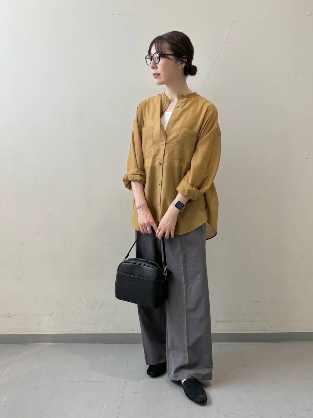 イエロー系のシャツ/ブラウス、ブラック系のショルダーバッグ、グレー系のその他パンツを着用したレディースの夏コーディネートの2枚目の写真