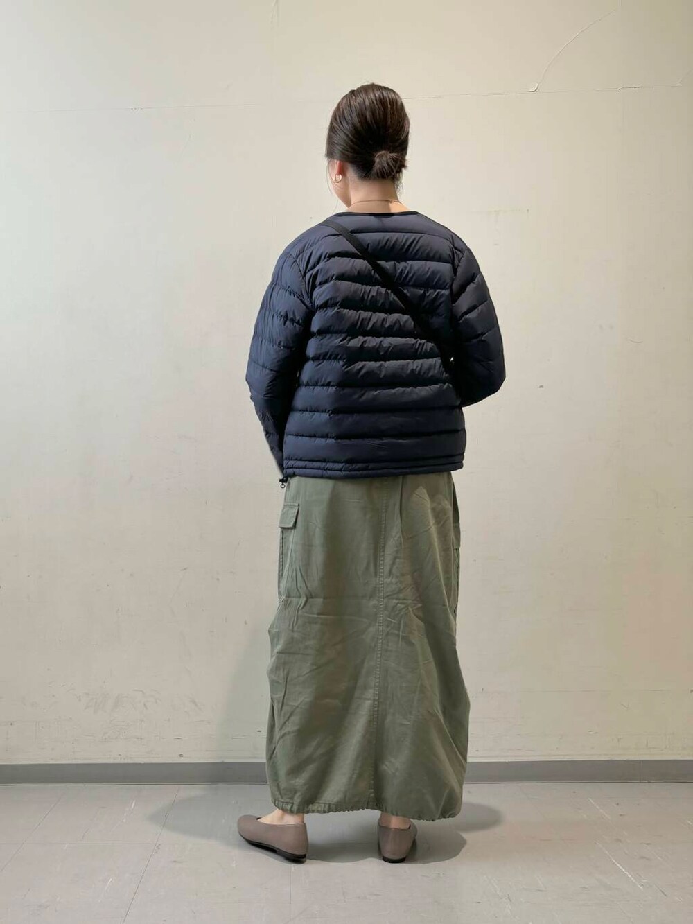 ベージュ系のパンプス、ベージュ系のTシャツ/カットソー、グリーン系のスカートを着用したレディースの秋コーディネートの3枚目の写真