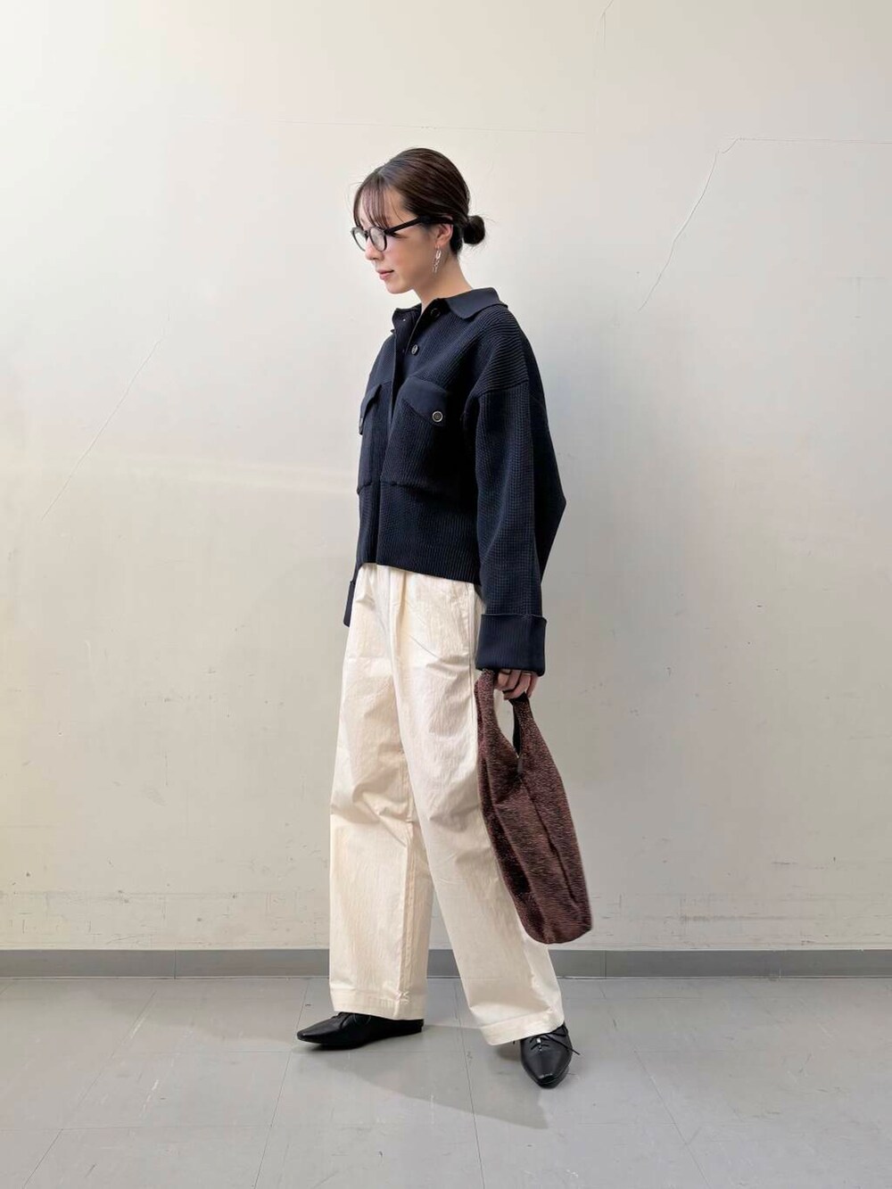 ブラック系のその他シューズ、ブラウン系のトートバッグ、ホワイト系のその他パンツを着用したレディースの冬コーディネートの2枚目の写真