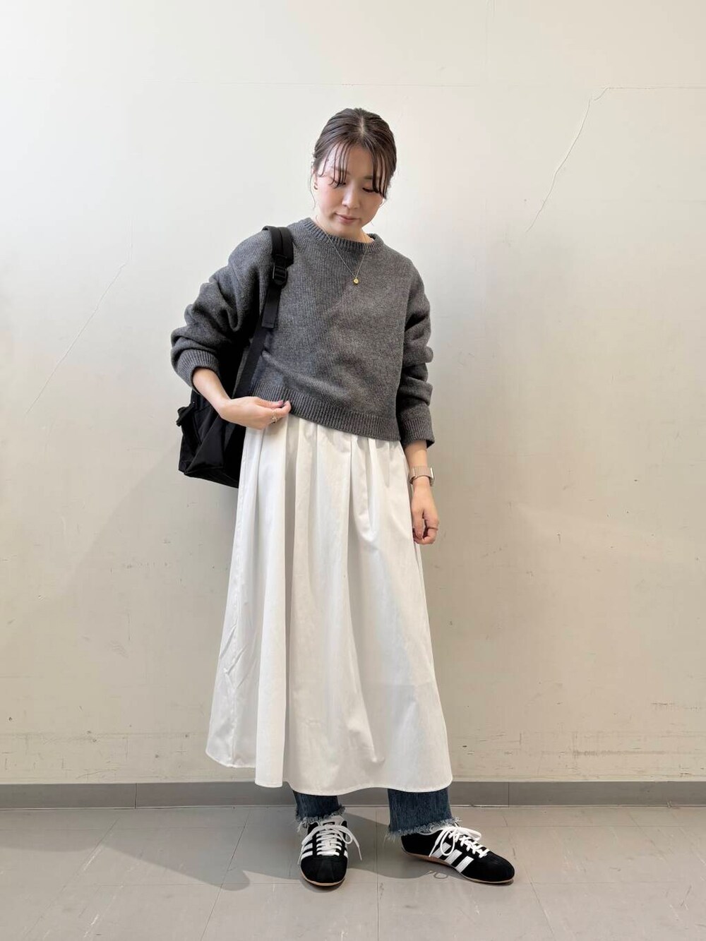 ブラック系のバックパック/リュック、グレー系のニット/セーター、グレー系のワンピースを着用したレディースの冬コーディネートの4枚目の写真